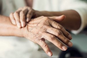 Senior Holding One Hand Steady with Other Hand
