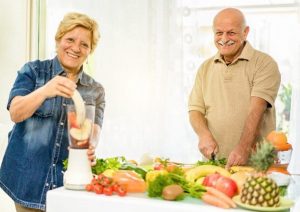 Senior Couple Cutting and Blending Fruits and Vegetables