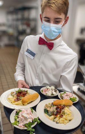 Server with Mask Carrying a Tray of Food